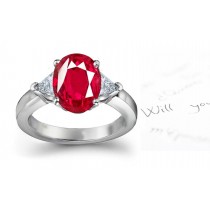 Classic Ruby Engagement Ring: Platinum ruby oval and diamond trillions three stone engagement ring.