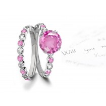 A timeless, design with a deep pink 1.0 carat round sapphire & halo of well-cut White Diamonds & sapphires in bridal set
