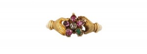 A 16th century amuletic jewelry the ivory hand wearing gold rings set with an emerald and a garnet